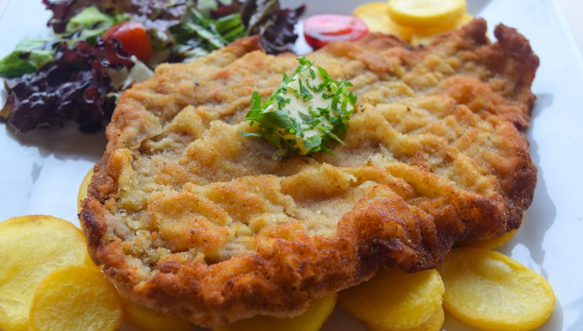 Шницел по виенски върху чипс от пресни пържени картофи
